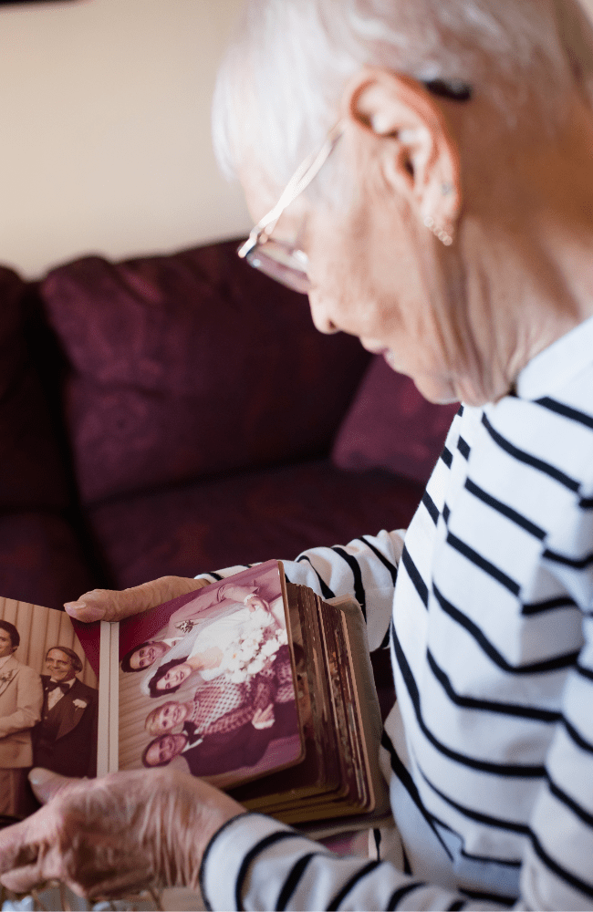 Kavod Senior Life resident, Bernice, looks through a family photo album
