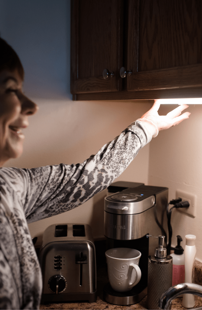 Kavod Senior Life resident turns new lighting on in her kitchen