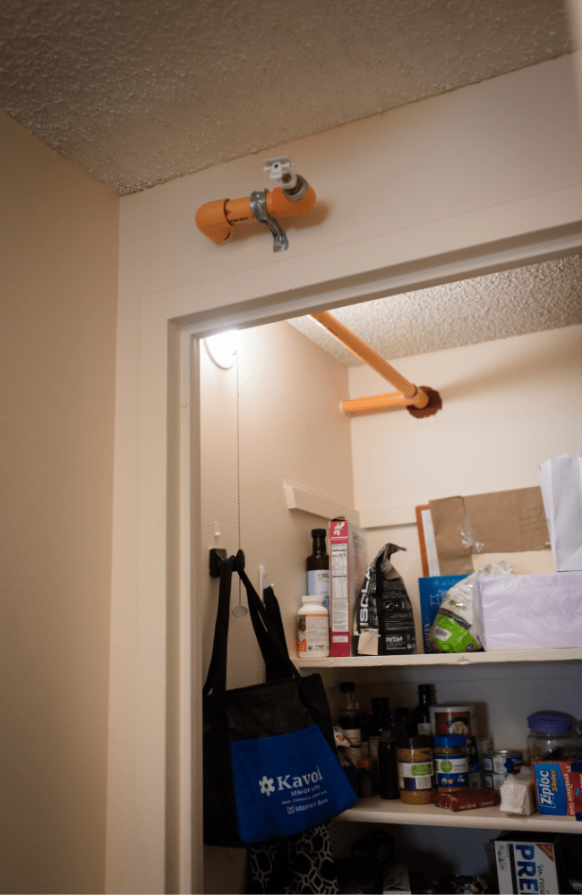 A light bulb brightens a dark closet in an apartment at Kavod Senior Life